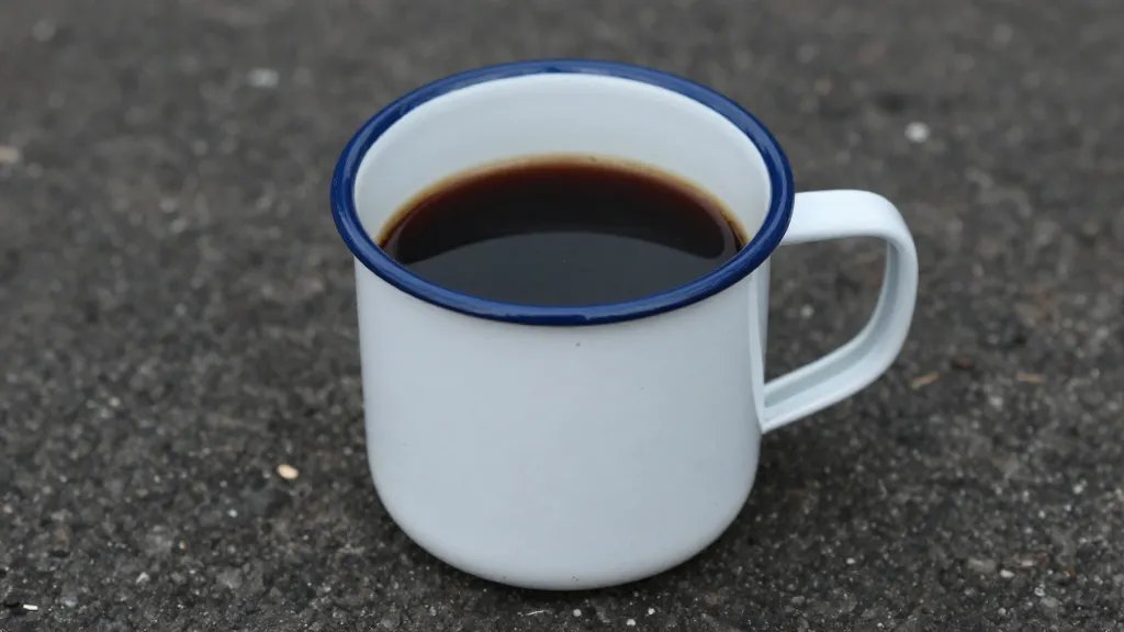 Single enamel camping mug filled with black coffee